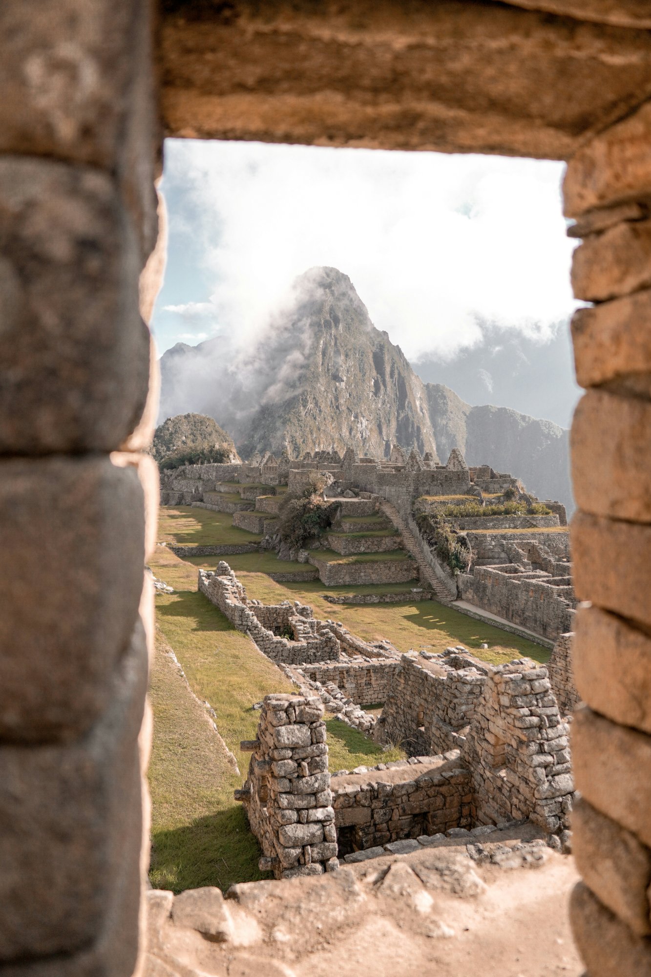 Machu Picchu ruins seen through a stone window — the Inca dreamscape between earth and sky