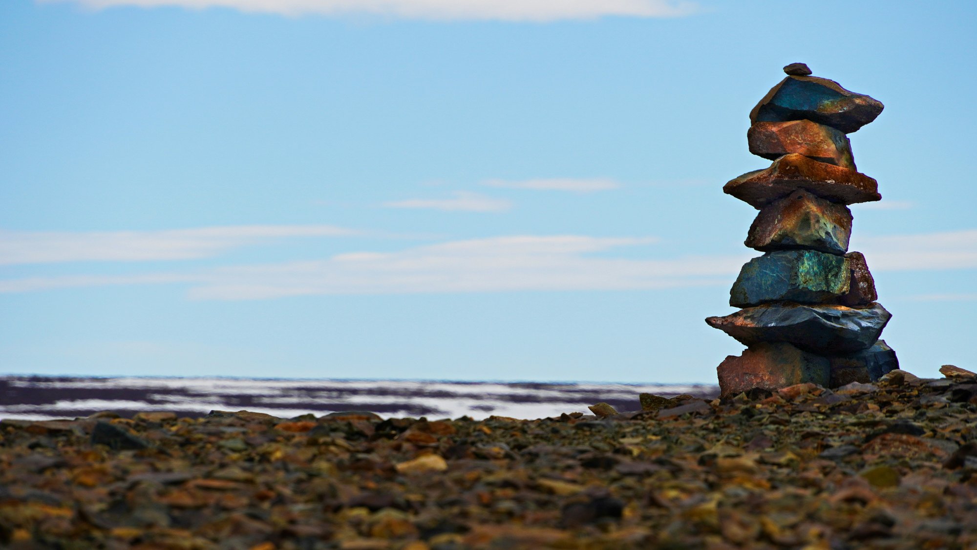 Inuit inuksuk stone cairn against Arctic sky — a guide for travellers between worlds